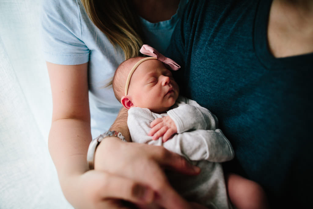 parents holding newborn baby girl