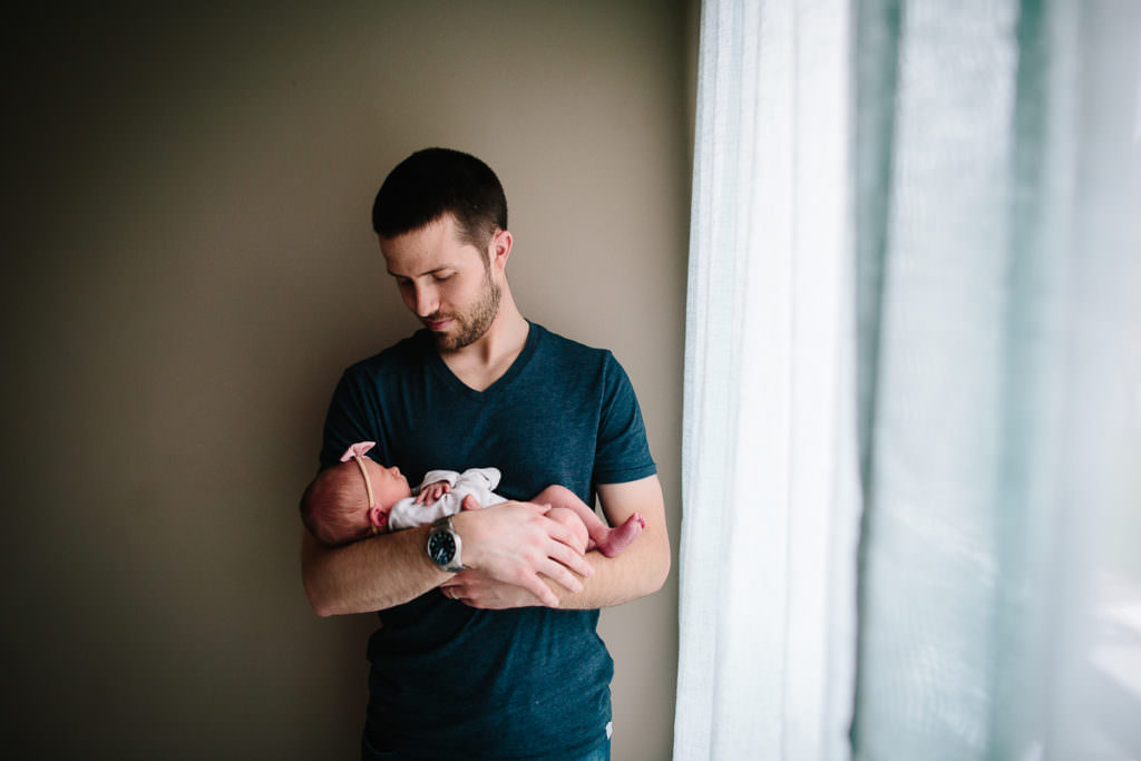 dad holding and looking at baby girl