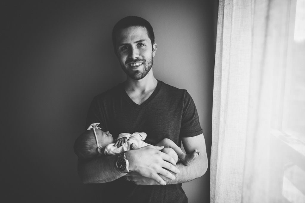 black and white dad holding newborn baby girl