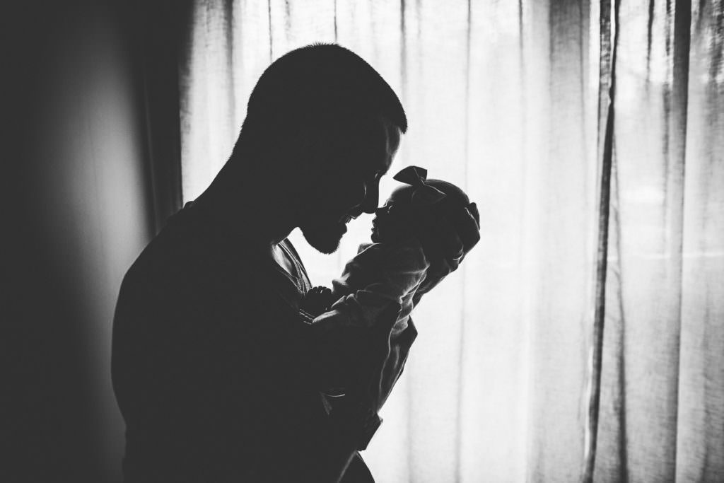 silhouette dad touching nose with baby girl