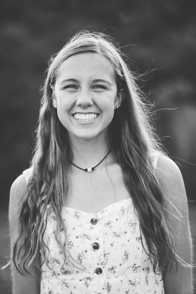 young woman with long brown hair and white dress