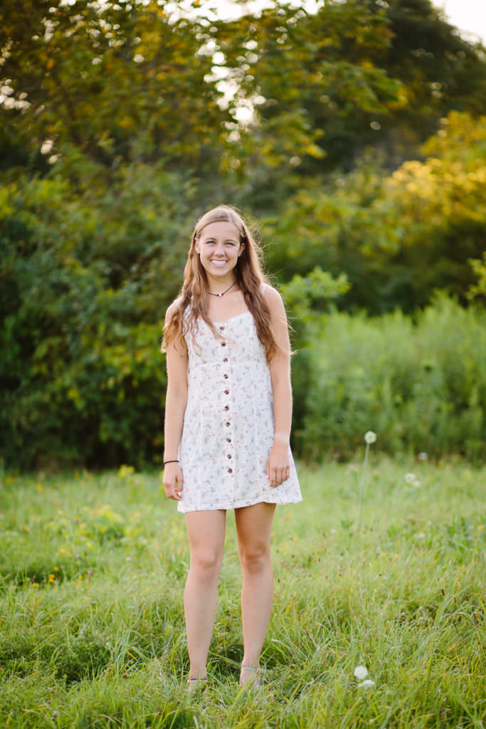 college girl in white dress in field