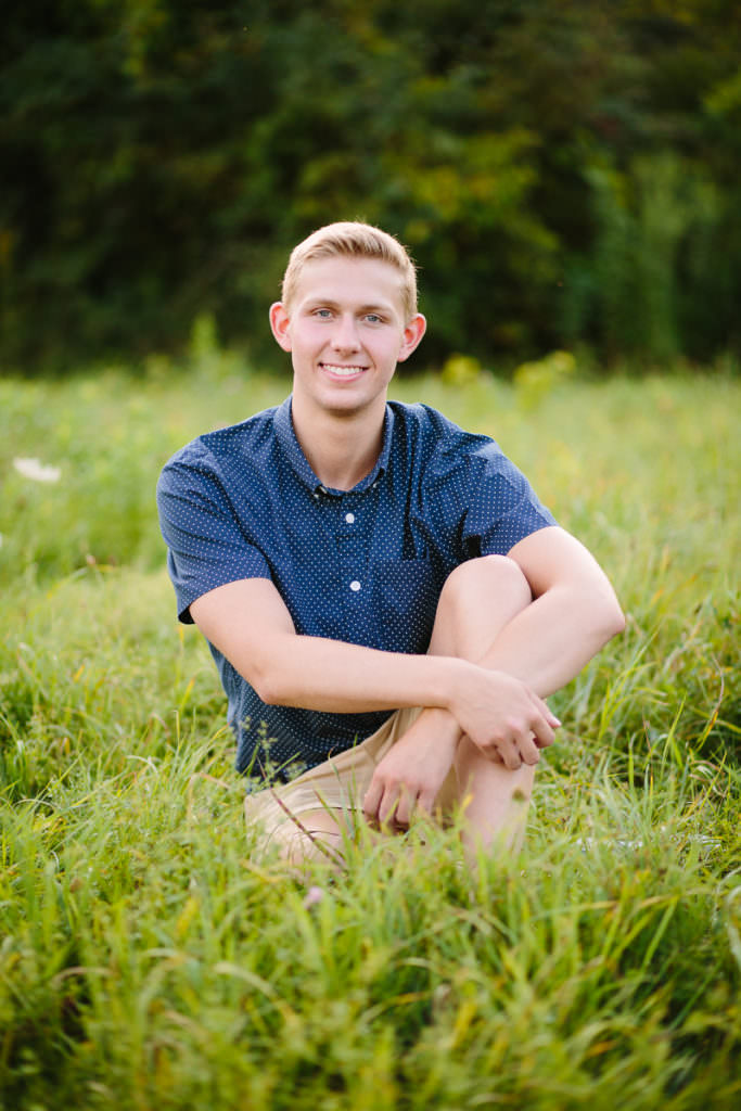 senior boy knee up arms crossed sitting