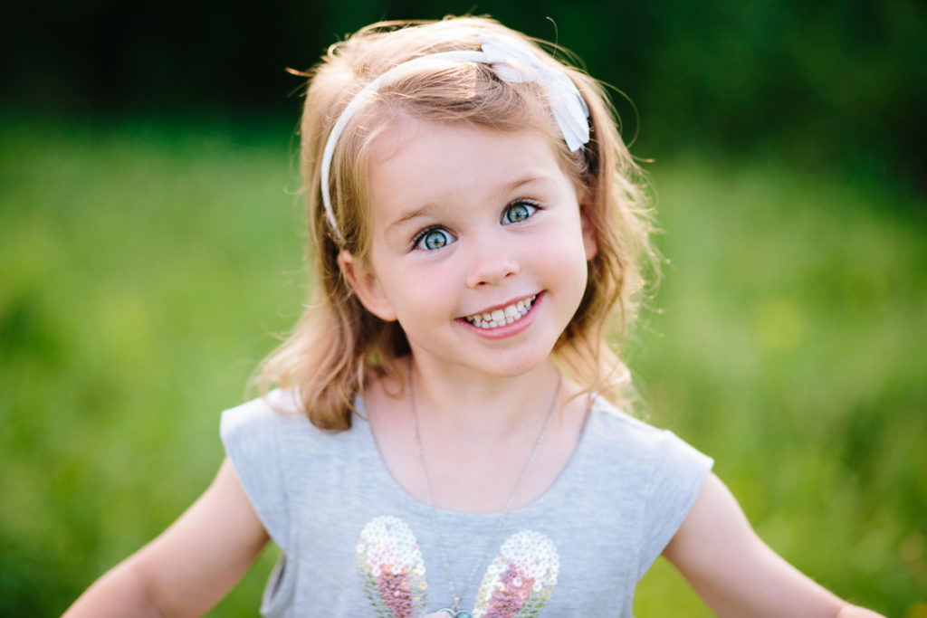 blue eyed little girl in field