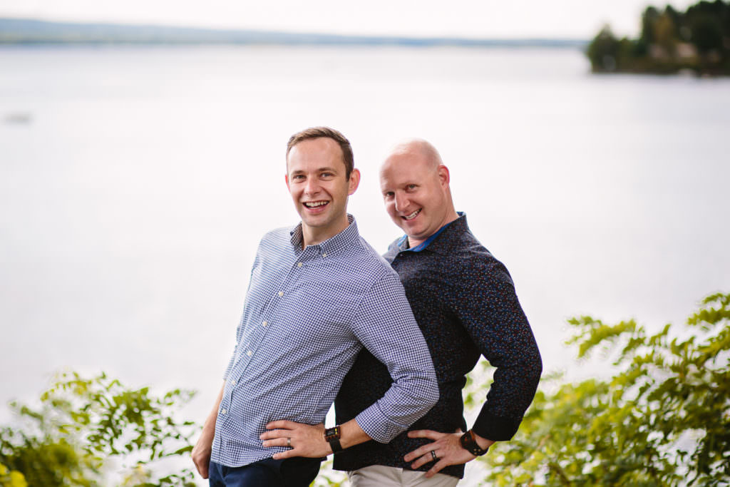 gay married couple posing at lake house
