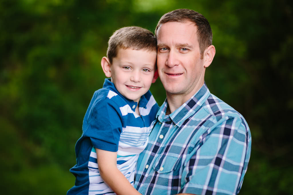 dad with plaid shirt holding son