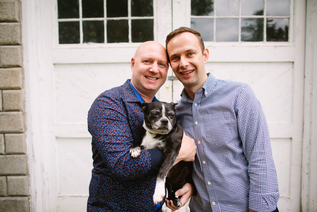 married gay couple holding black dog