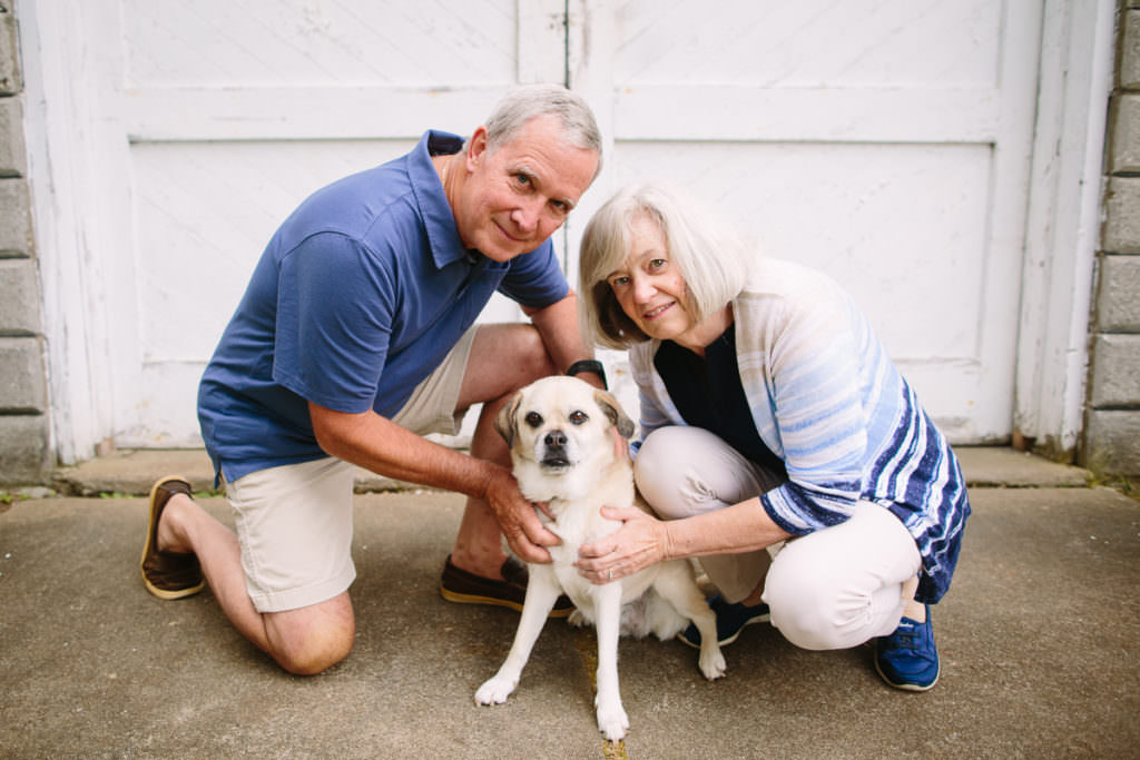 older couple kneeling by pet dog