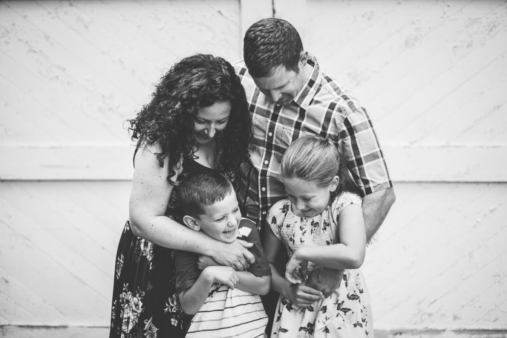 family of four hugging