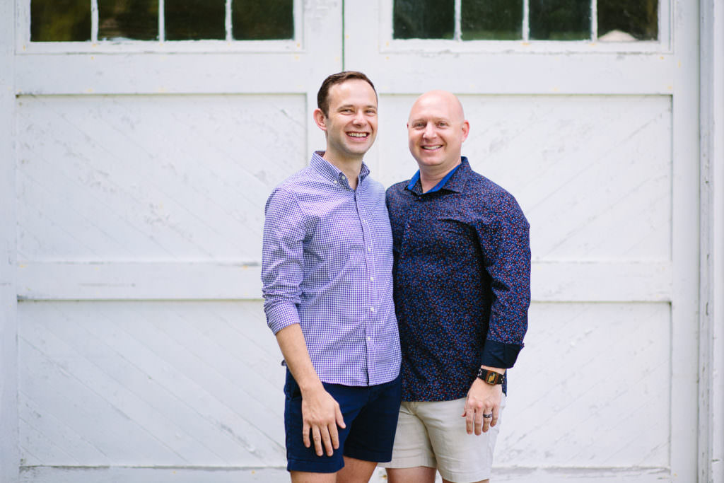 husbands standing close by lake house