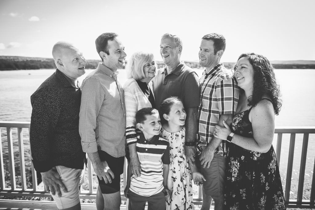 family of eight standing by lake sacandaga