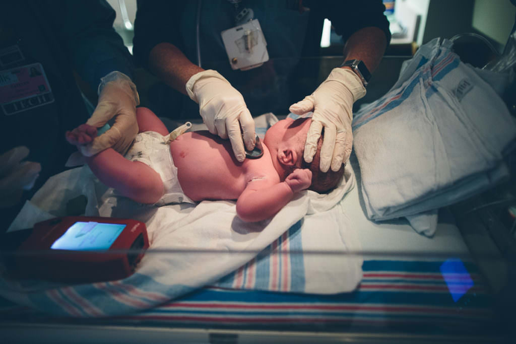 nurse doing newborn exam after birth
