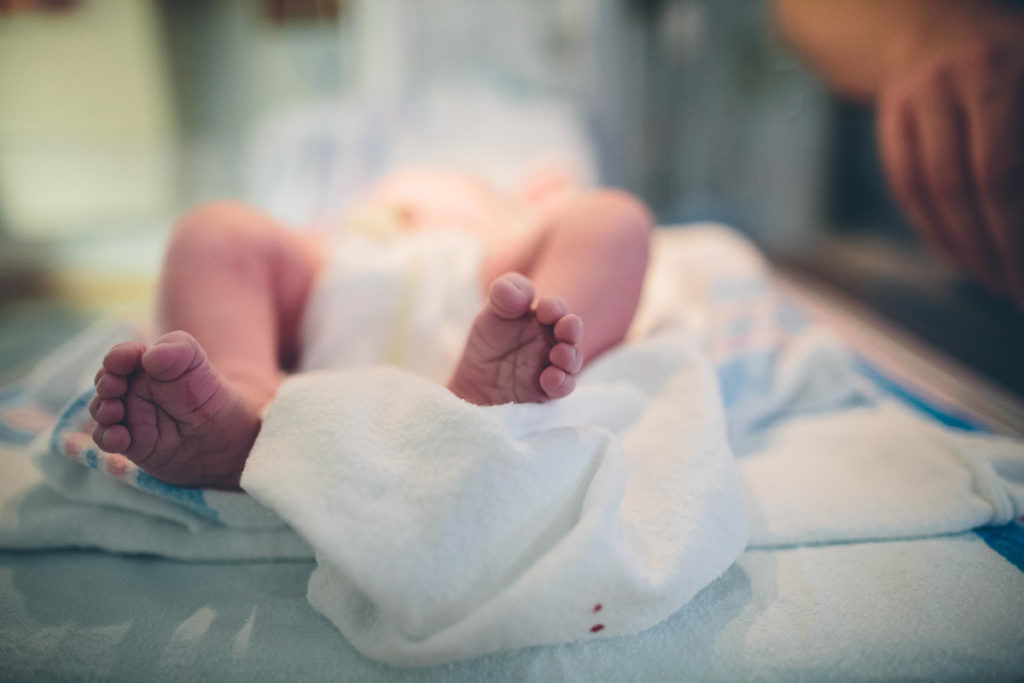 newborn baby feet on swaddle blanket