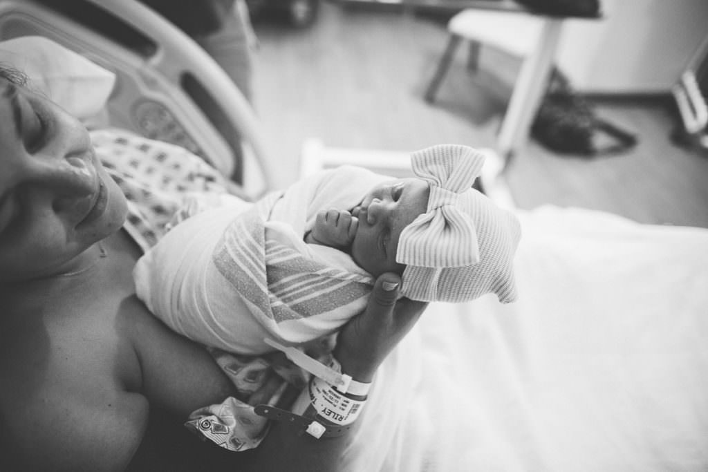 newborn baby girl swaddled with bow hat
