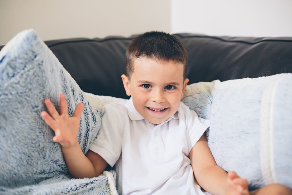 little boy on couch spread arms