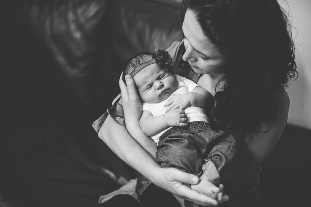mom holding baby girl on couch