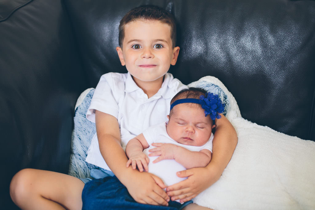 big brother holding baby sister at home in niskayuna