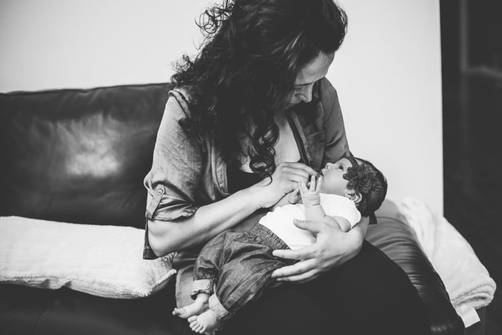 newborn baby girl looking up at mom