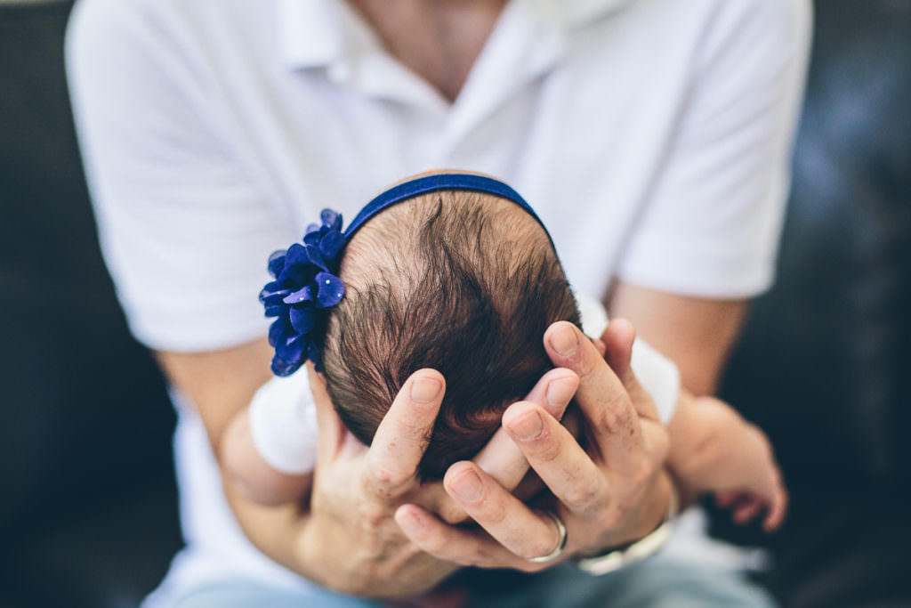 close up of dad holding newborn baby head