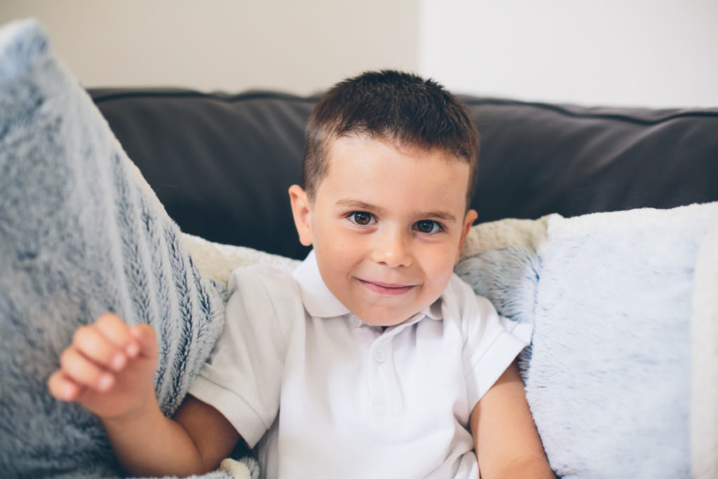 little boy smiling on couch at home