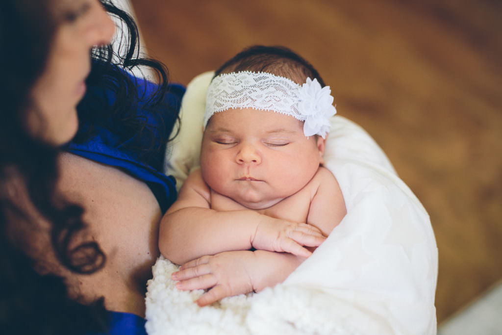 newborn baby girl wrapped in soft white blanket