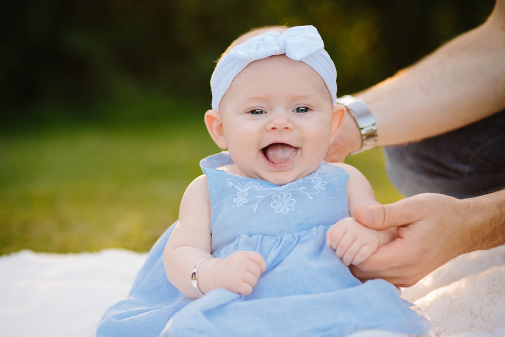 smiling baby girl in blue dress