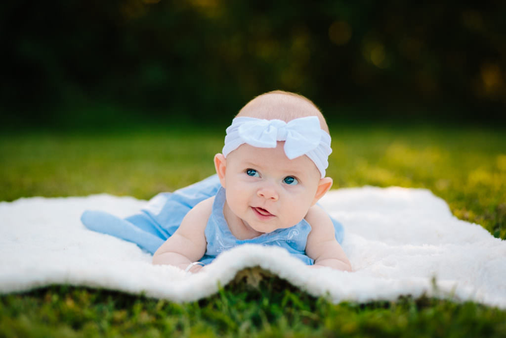 baby girl on blanket with white bow