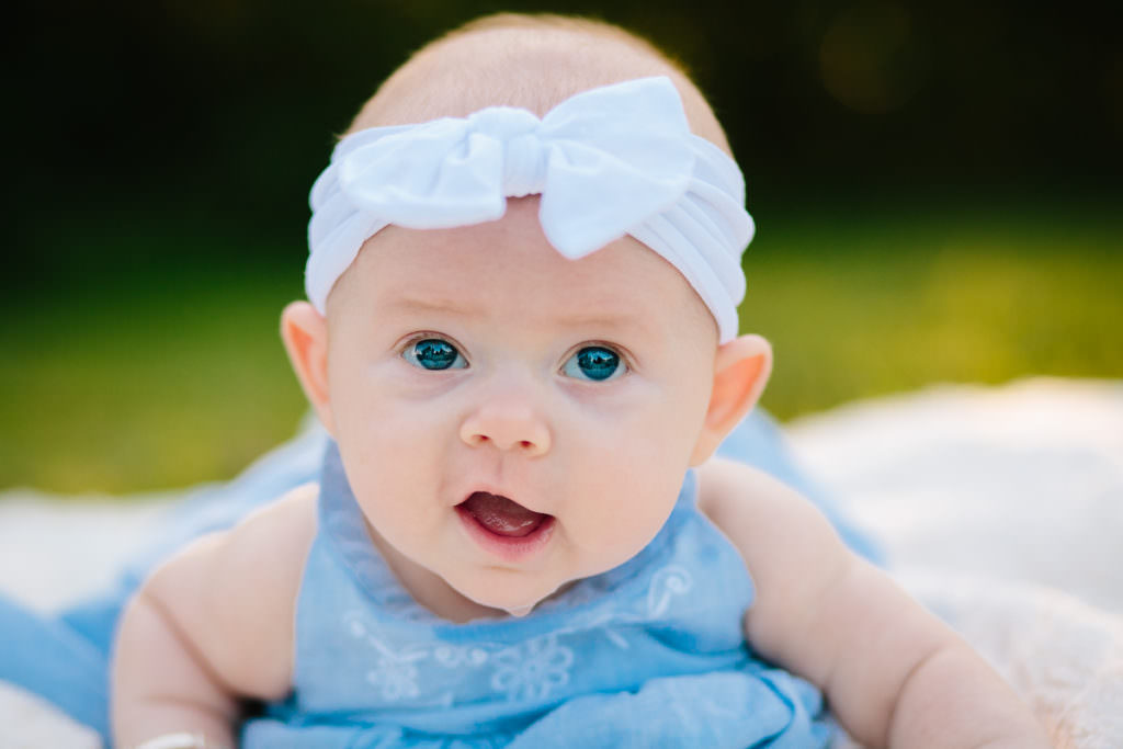 baby with blue eyes white bow