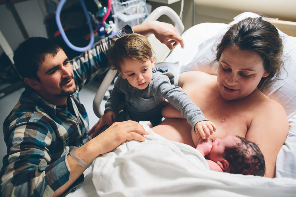 big brother touching his new baby brother