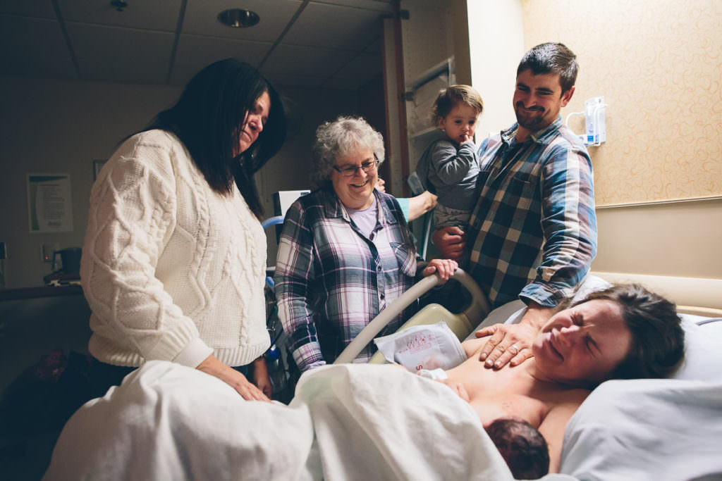 both grandmothers husband and toddler congratulation mom after vbac