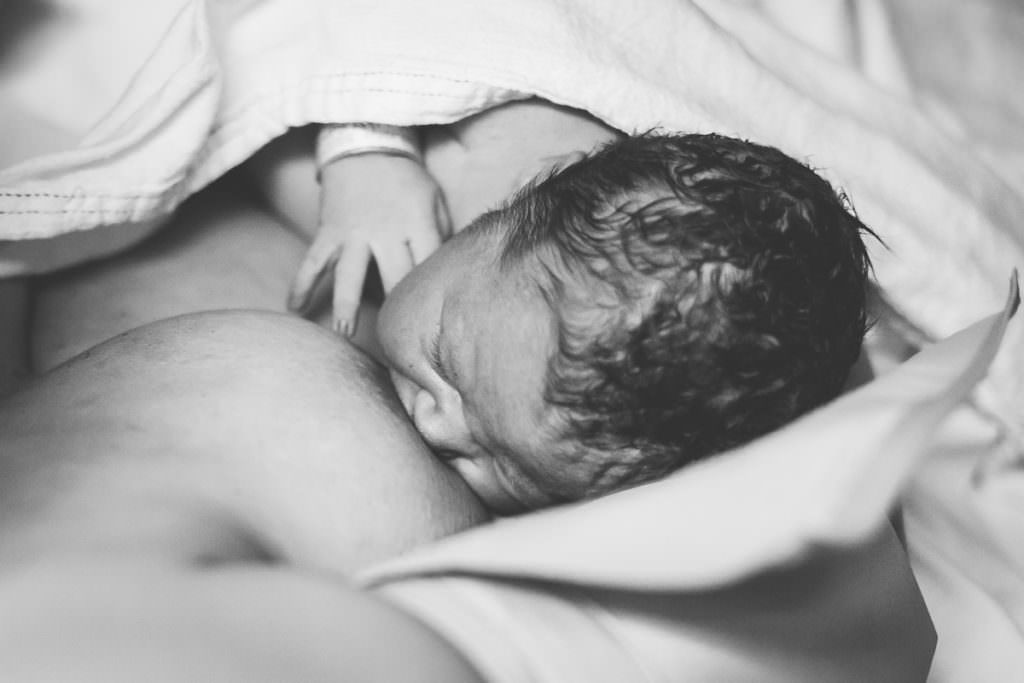 black and white image of baby breastfeeding