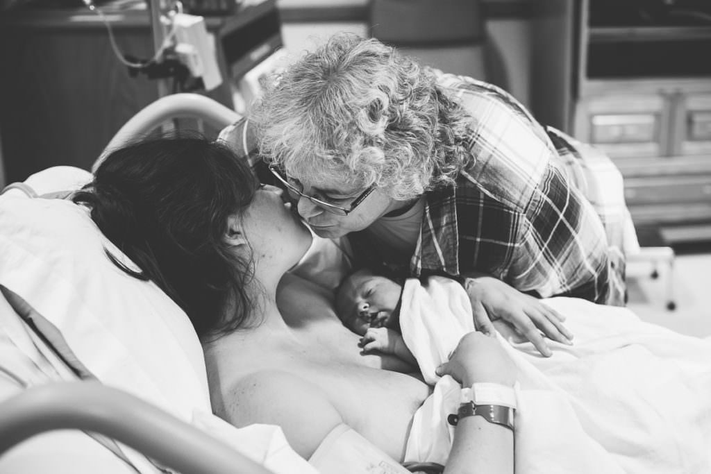 mother in law gives daughter a kiss on the cheek at the hospital