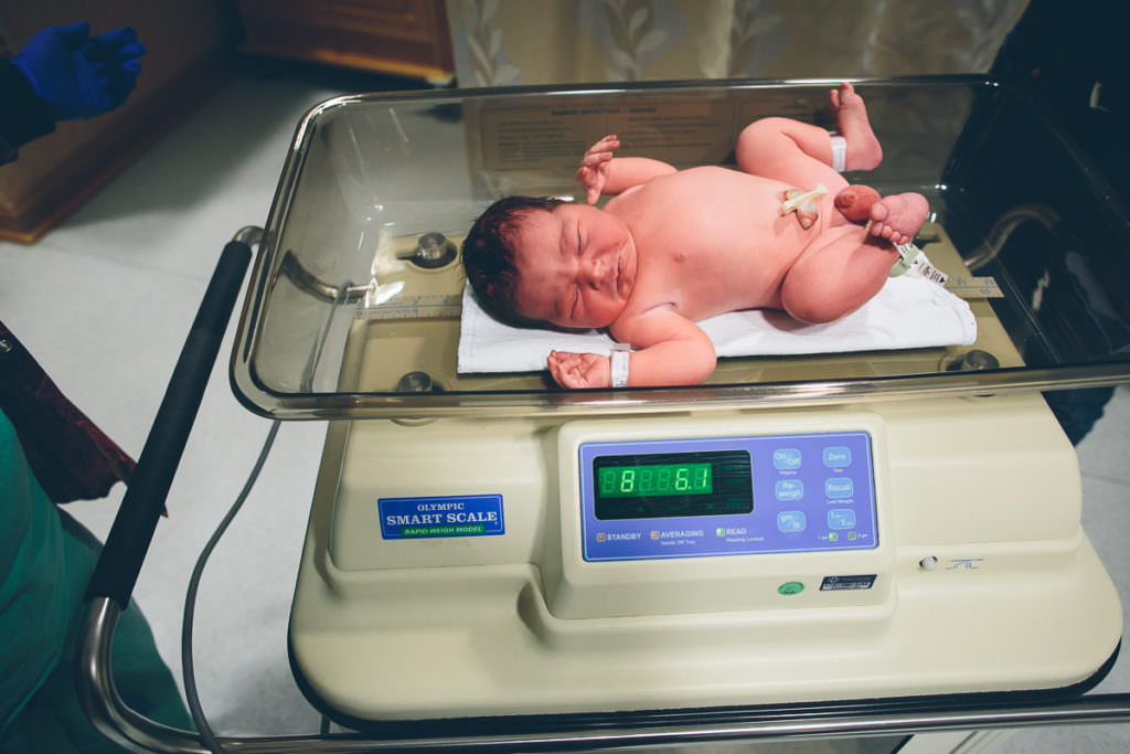 newborn baby getting weighed at birth center after birth