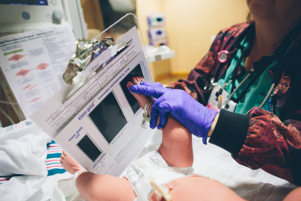 nurse getting footprints at newborn baby boy at Burdett Birth Center