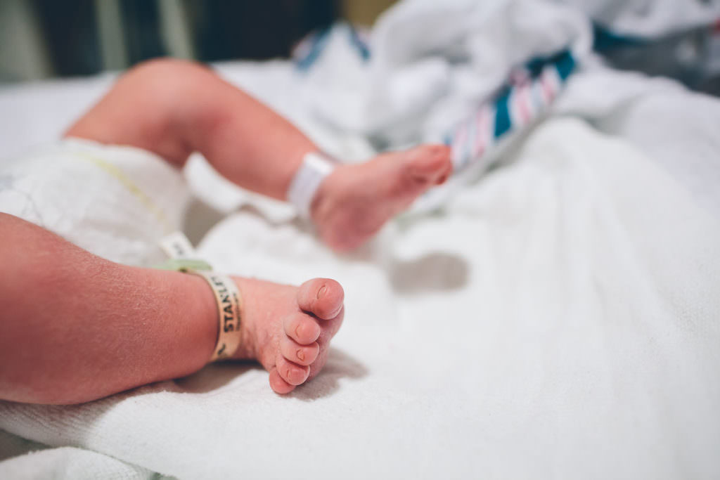 close up of newborn baby feet with safety tag