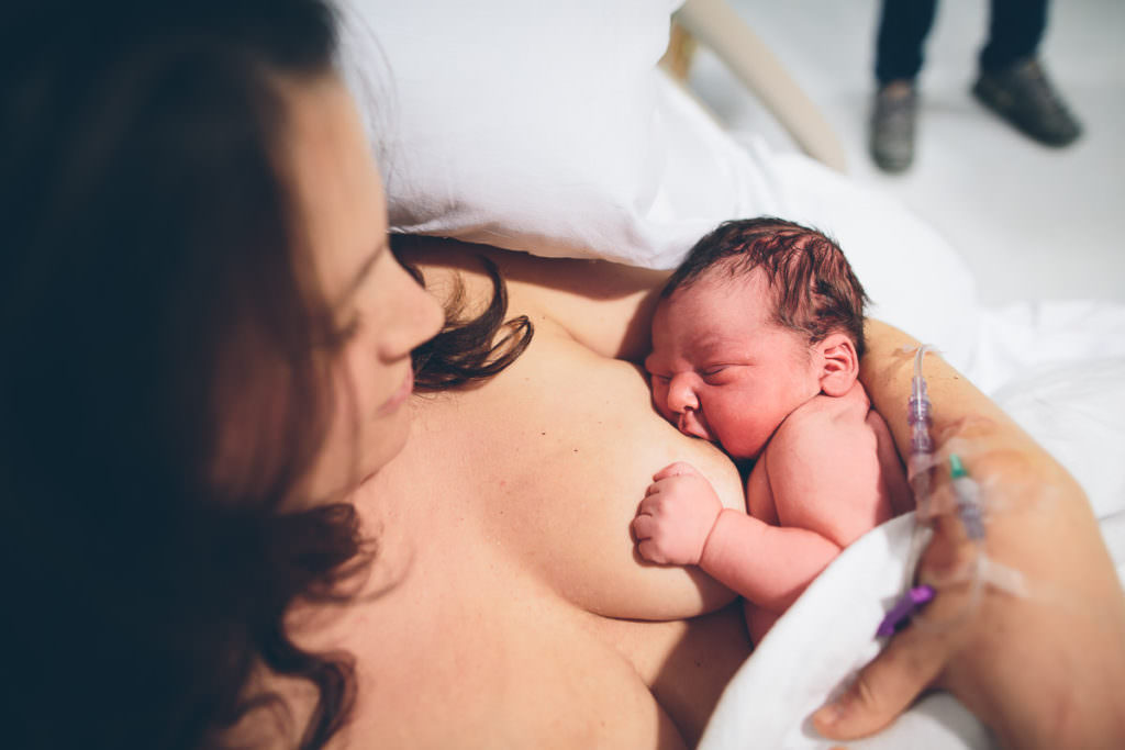 mom breastfeeding newborn baby boy while at the hospital