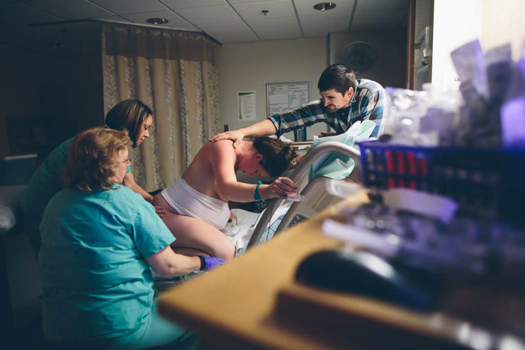 midwife nurse and husband help support mom in labor