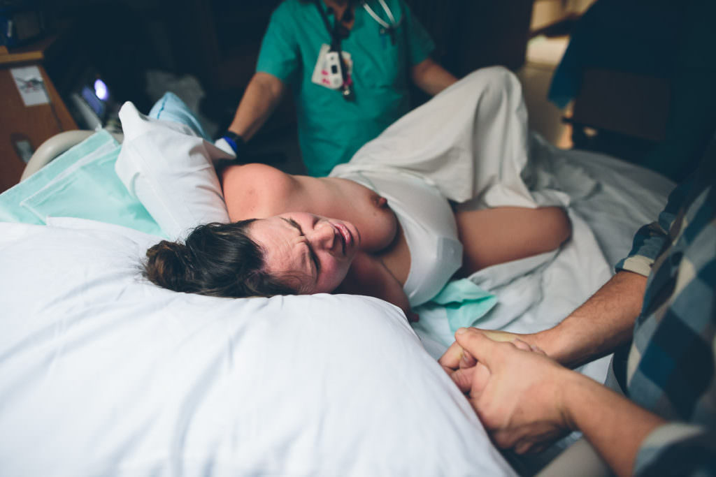 laboring mom during a contraction on birth bed in hospital