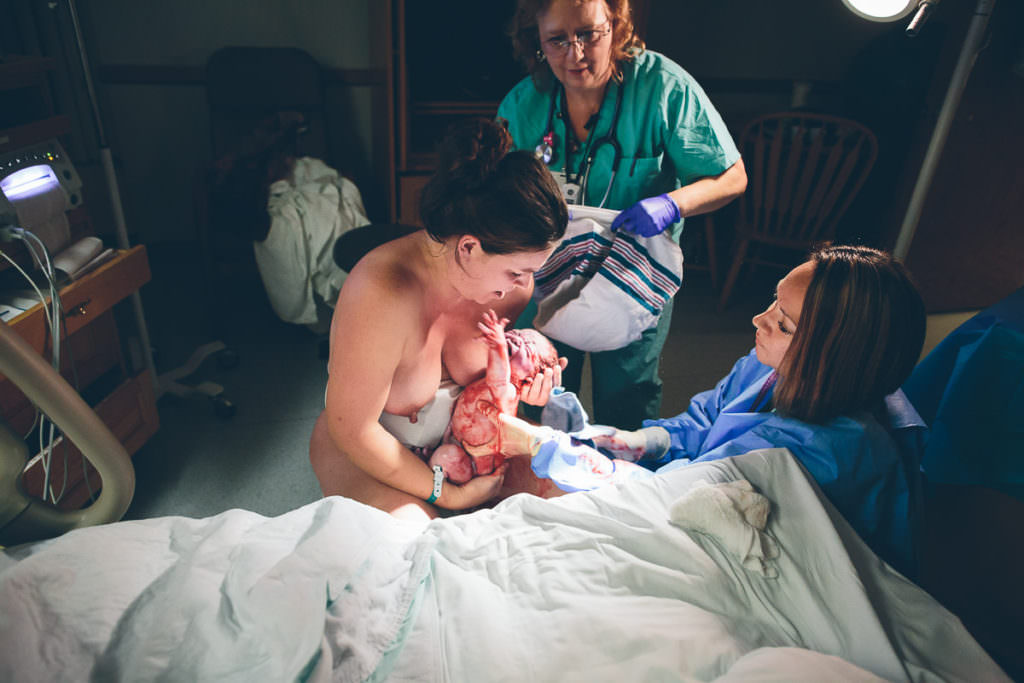 midwife sets a baby that was just born on moms chest