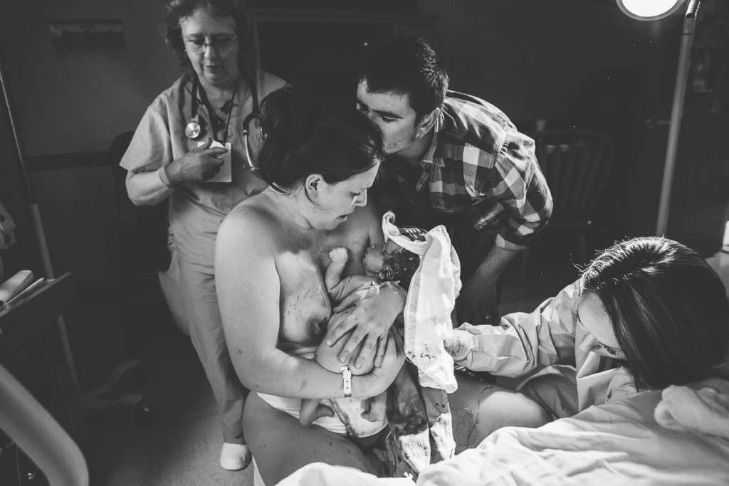 dad comes around and kisses mom on the head right after she has baby