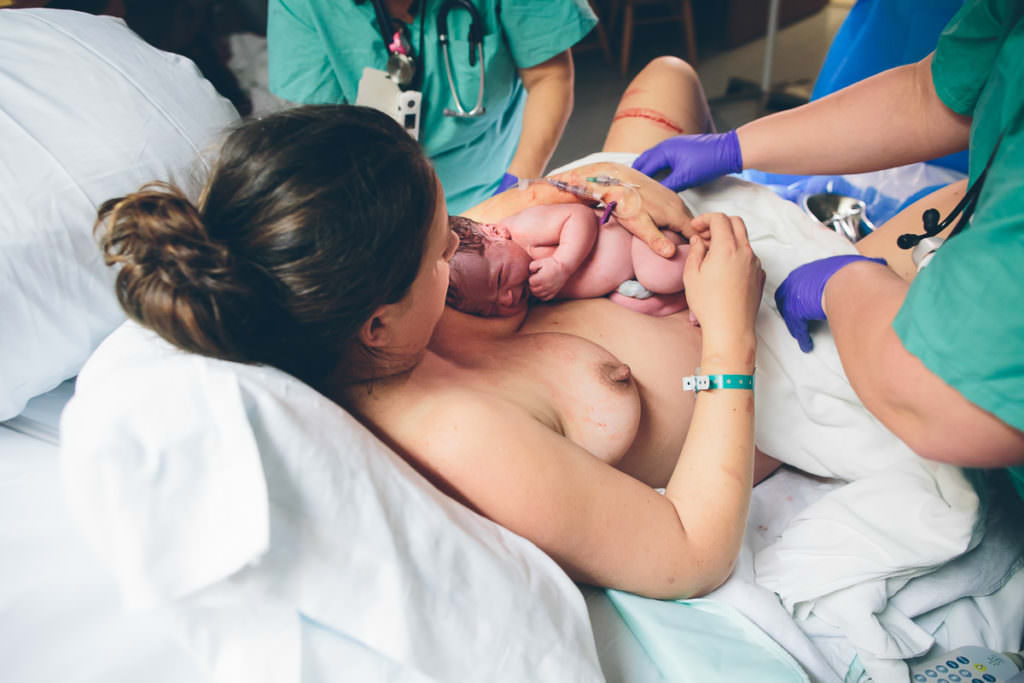 nurses wipe blood off mom and baby right after vbac birth