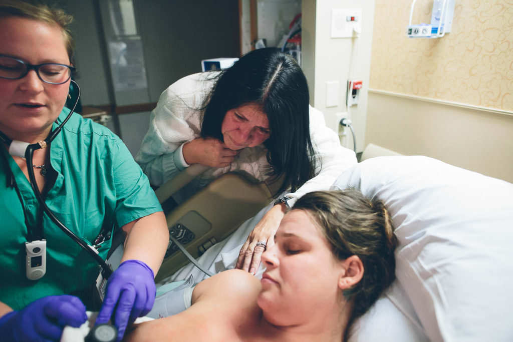 grandma looks down at new grandson right after he is born