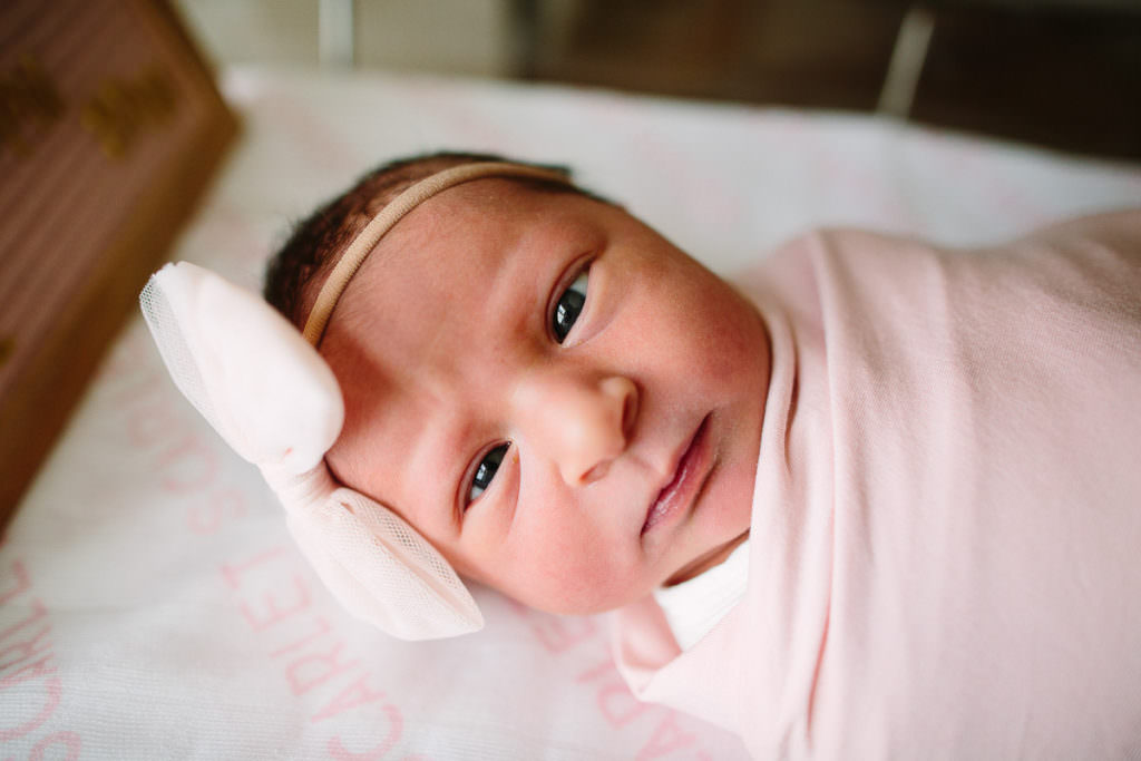 Fresh 48 session newborn baby girl eyes wide open with big pink bow and pink blanket in Saratoga Hospital New York