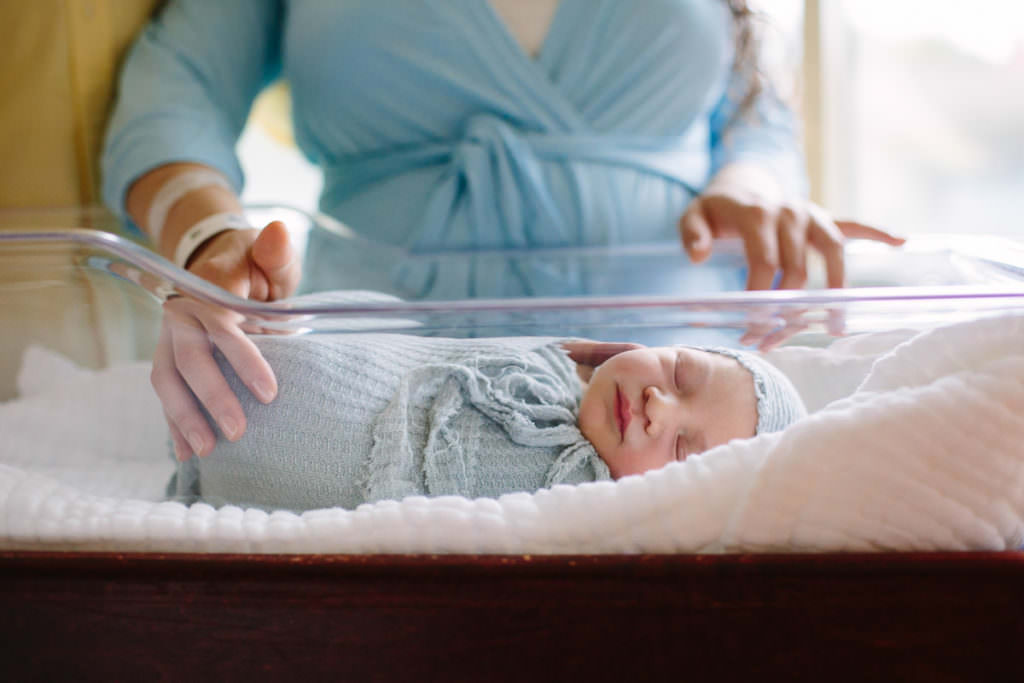 mom standing next to baby in a bassinet during fresh 48 session at St Peters hospital in Albany NY