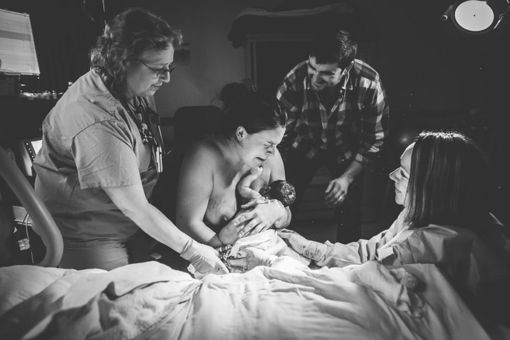 emotional mom surrounding by husband nurse and midwife after she had her vbac in Troy NY