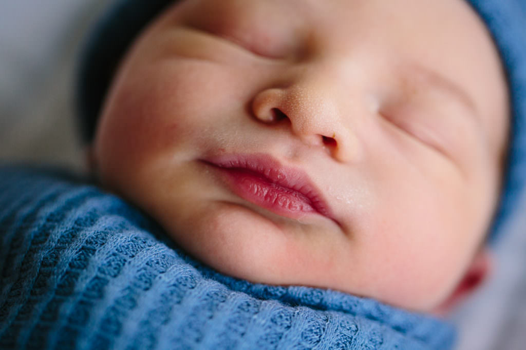 newborn baby boy close up on red lips