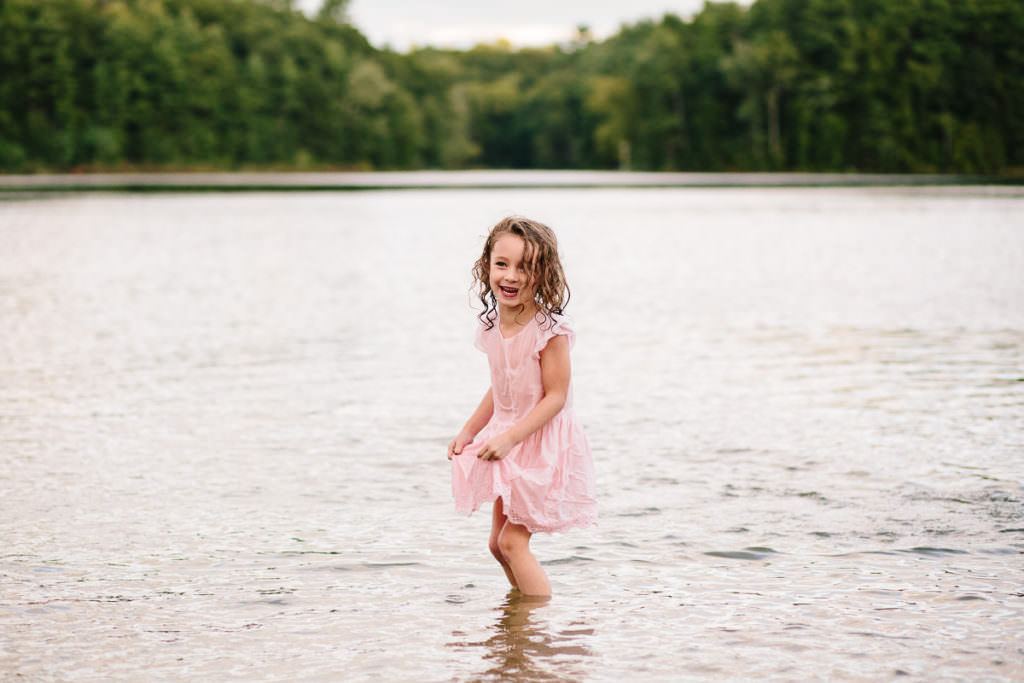 little girl in pink dress plays in the lake and Moreau State park in New york