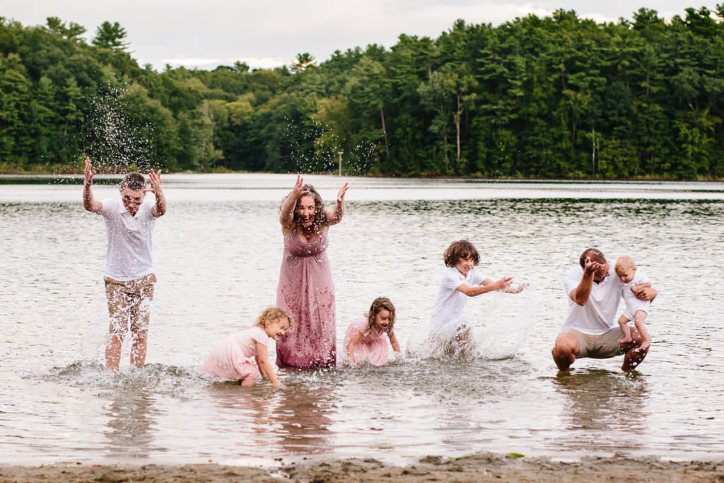 family running and splashing in lake