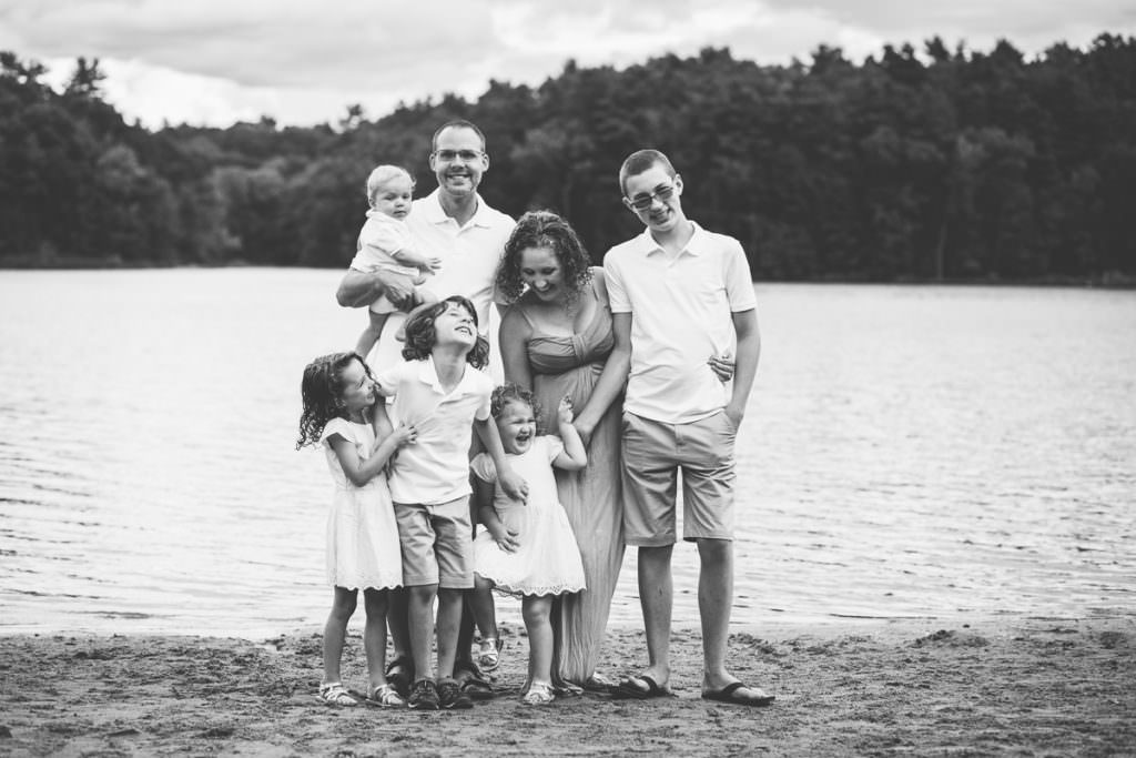 black and white picture of big family laughing on a beach