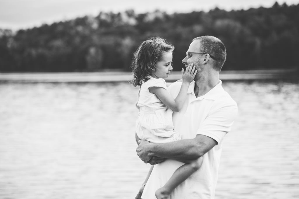 dad holding daughter and she touches his cheek